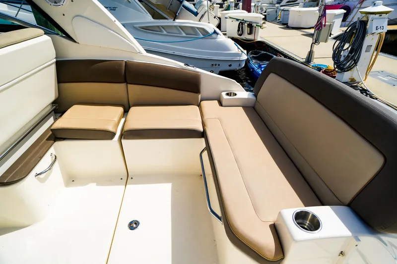 Slide: The Image of 2015 Sea Ray 260 Sundancer boat interior with beige seating and cup holders. - 7