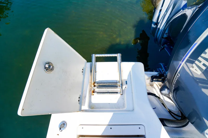 Slide: The Image of 2016 Robalo 206 Cayman boat with open hatch and ladder near water. - 16