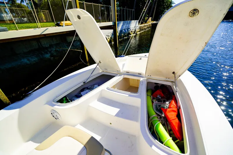 Slide: The Image of 2016 Robalo 206 Cayman boat with open storage compartments by the water. - 5