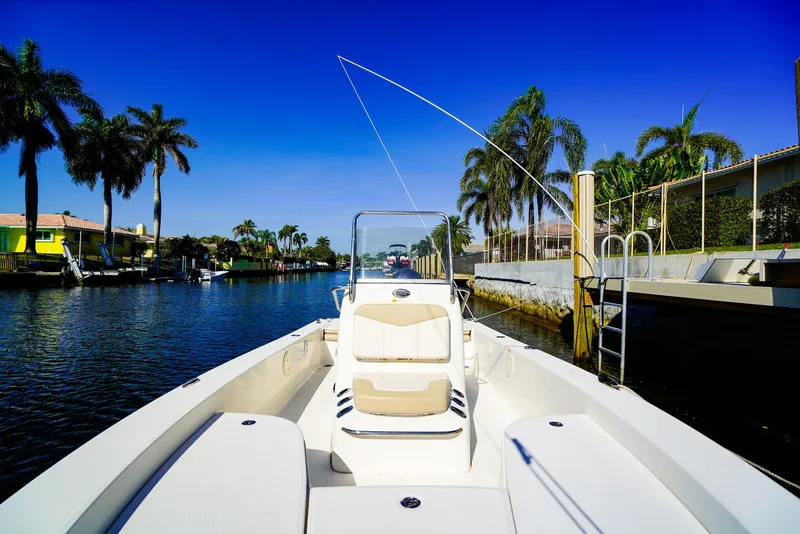 Slide: The Image of 2016 Robalo 206 Cayman boat cruising in a sunny, palm-lined canal. - 6