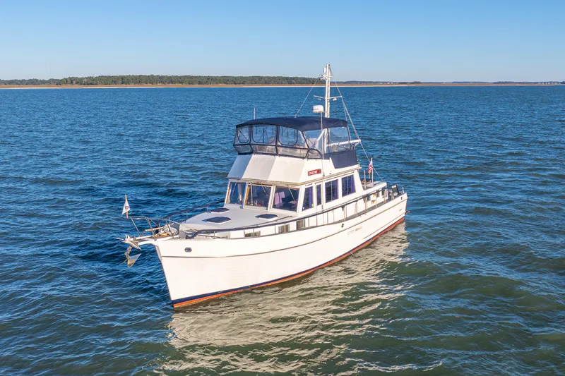 The Image of 1989 Grand Banks 46 Classic yacht cruising on open water under clear blue skies. - 0