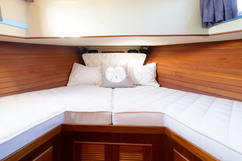 Slide: The Image of Cozy cabin interior of 1989 Grand Banks 46 Classic yacht with wooden paneling and white bedding. - 22