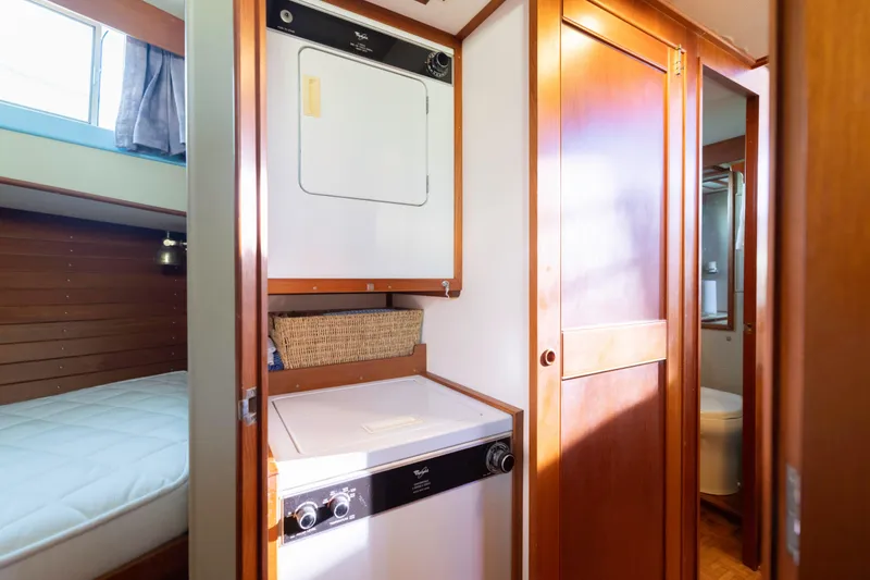 Slide: The Image of Laundry area inside 1989 Grand Banks 46 Classic yacht with wood paneling and compact washer-dryer. - 23