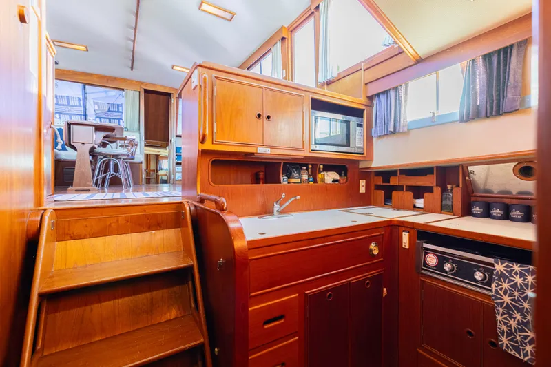 Slide: The Image of 1989 Grand Banks 46 Classic yacht interior with wooden cabinetry and modern kitchen amenities. - 25
