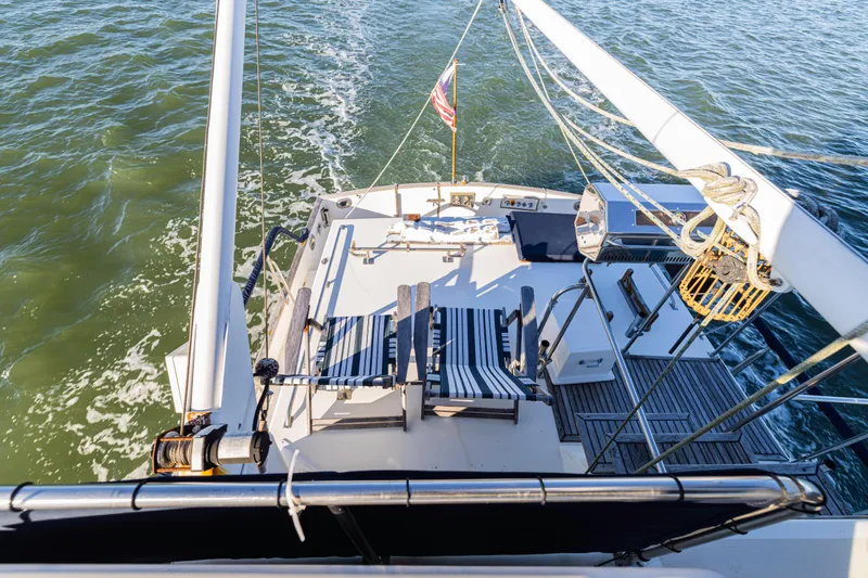 Slide: The Image of 1989 Grand Banks 46 Classic yacht deck with striped chairs, cruising on open water. - 42