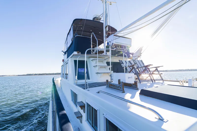 Slide: The Image of 1989 Grand Banks 46 Classic yacht cruising on calm waters under clear blue skies. - 49
