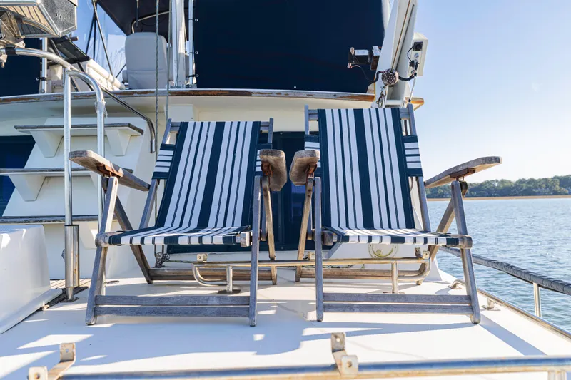 Slide: The Image of Two striped deck chairs on a 1989 Grand Banks 46 Classic yacht. - 52