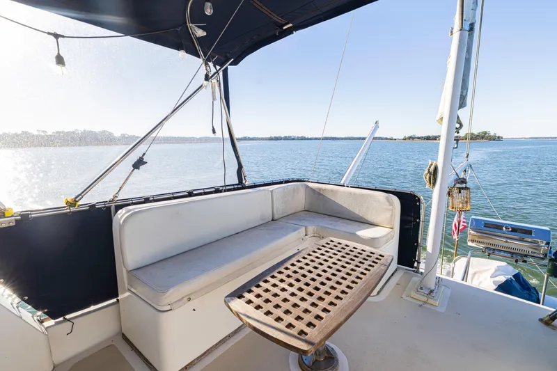 Slide: The Image of 1989 Grand Banks 46 Classic yacht deck with seating, table, and scenic water view. - 55