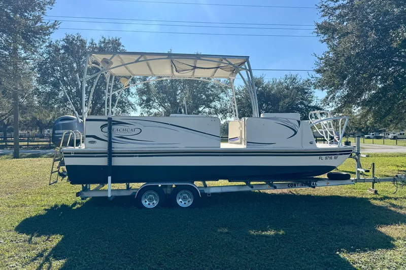 Slide: The Image of 2017 Beachcat 230 boat on trailer, parked on grass under clear blue sky. - 3