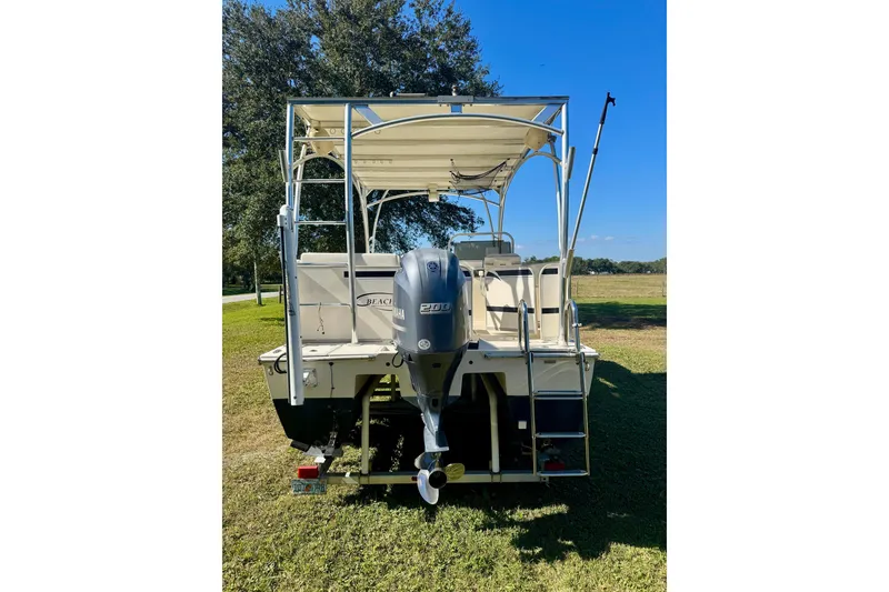 Slide: The Image of 2017 Beachcat 230 boat with Yamaha 200 engine, parked on grass under clear blue sky. - 4