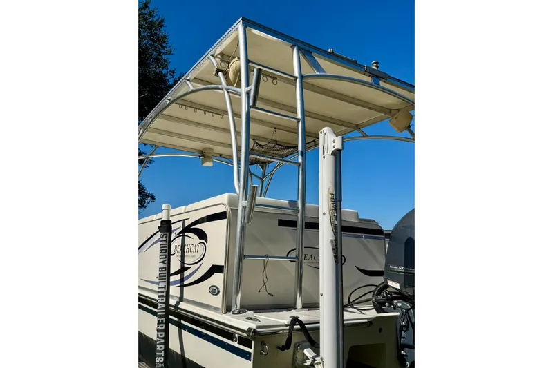 Slide: The Image of 2017 Beachcat 230 boat with canopy and motor, under clear blue sky. - 5