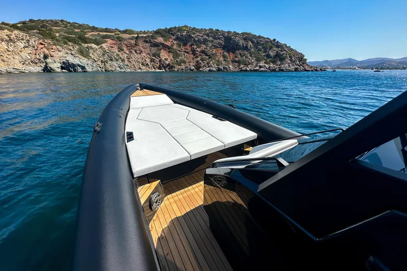 Slide: The Image of 2026 Rock Marine RM 36 boat cruising near rocky coastline under clear blue sky. - 17