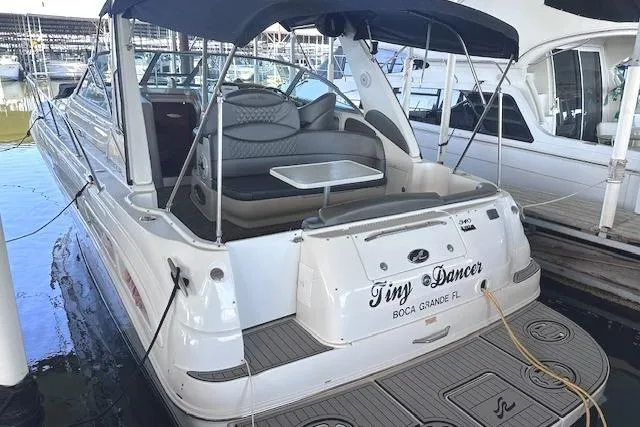 The Image of 2001 Sea Ray 340 Sundancer docked, featuring spacious seating and canopy. - 0