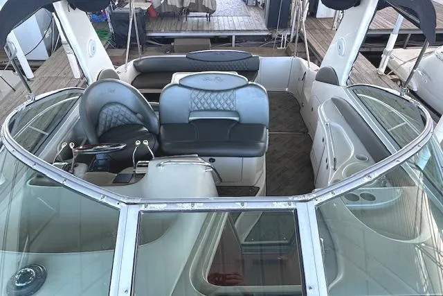 Slide: The Image of 2001 Sea Ray 340 Sundancer boat interior with leather seating and helm, docked at marina. - 10