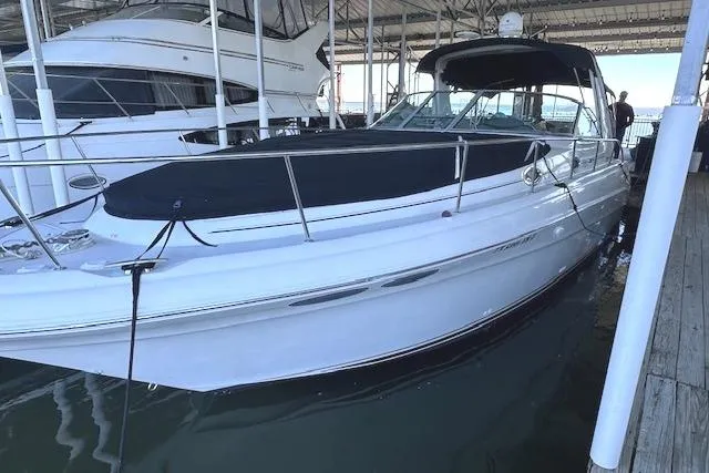 Slide: The Image of 2001 Sea Ray 340 Sundancer yacht docked in marina, covered deck, sleek design. - 2