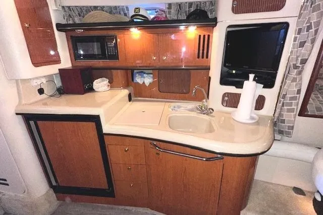 Slide: The Image of 2001 Sea Ray 340 Sundancer interior kitchen with wood cabinets and modern appliances. - 21