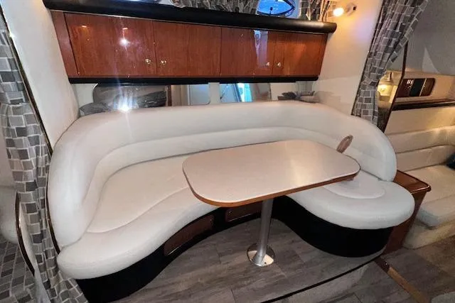 Slide: The Image of Interior of 2001 Sea Ray 340 Sundancer with curved seating and wooden cabinetry. - 22