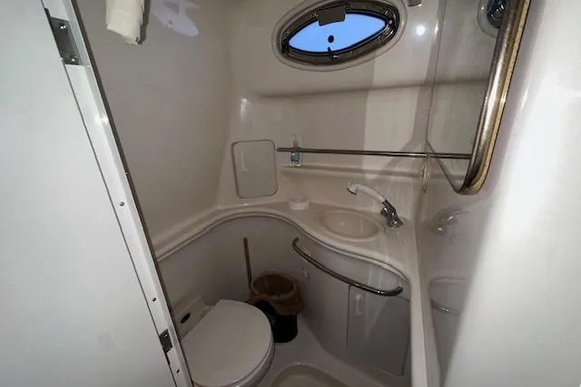 Slide: The Image of 2001 Sea Ray 340 Sundancer bathroom with compact design and oval window. - 26