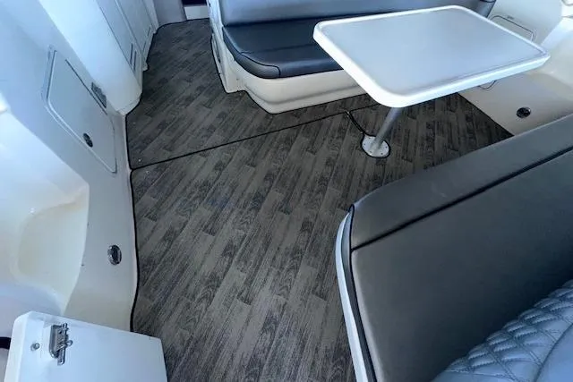 Slide: The Image of 2001 Sea Ray 340 Sundancer interior with wood-style flooring and cushioned seating area. - 29
