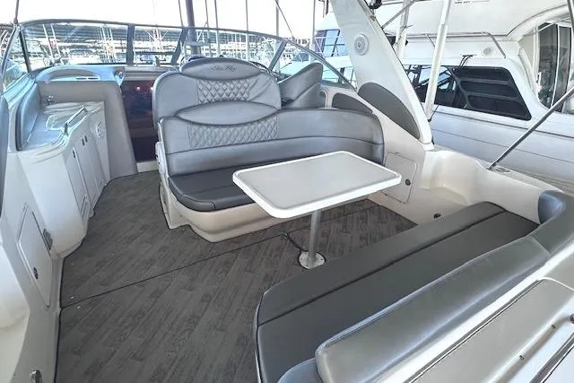 Slide: The Image of 2001 Sea Ray 340 Sundancer interior with gray seating and table, docked at marina. - 5