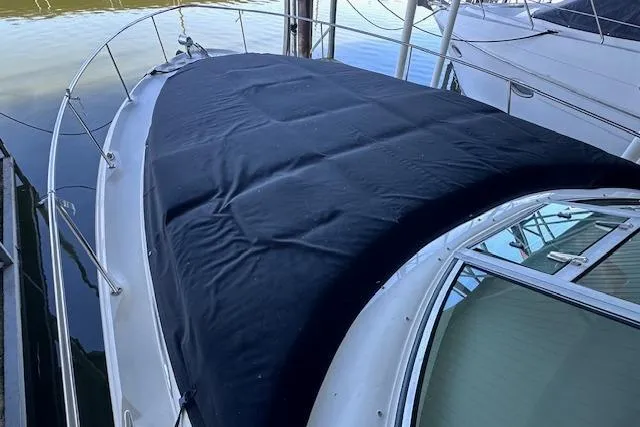 Slide: The Image of 2001 Sea Ray 340 Sundancer with black cover docked at marina. - 9