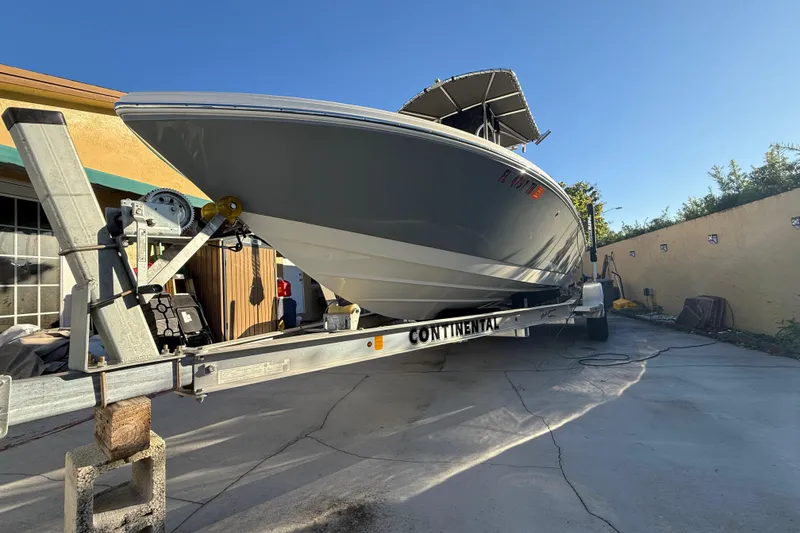 Slide: The Image of Pathfinder 2005 TRS boat on trailer, parked in driveway, sunny day. - 12