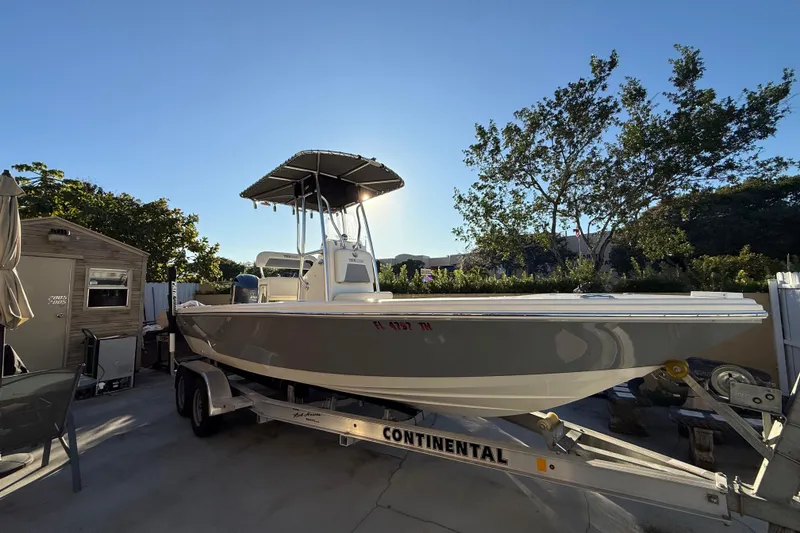 Slide: The Image of Pathfinder 2005 TRS boat on trailer, parked outdoors, surrounded by trees and a shed. - 13