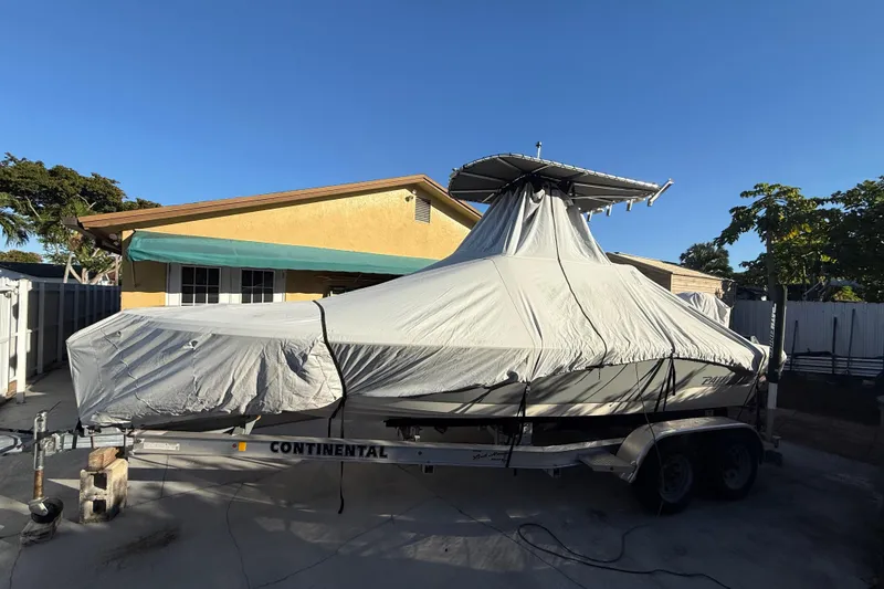 Slide: The Image of Covered 2005 Pathfinder TRS boat on trailer, parked in driveway, sunny day. - 15