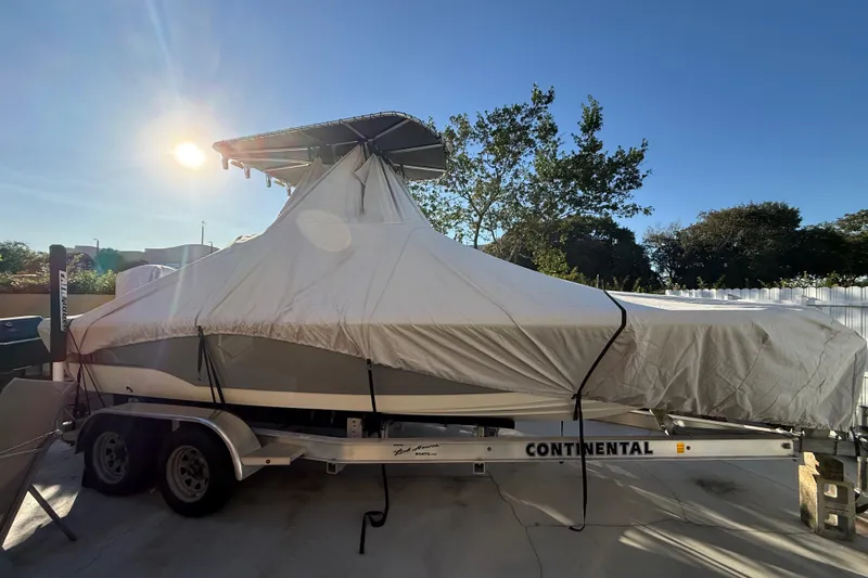 Slide: The Image of Covered 2005 Pathfinder TRS boat on Continental trailer under sunny sky, 2022. - 16