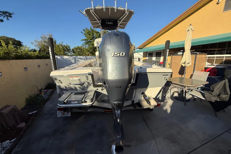Slide: The Image of Pathfinder 2005 TRS boat with Yamaha 150 engine, parked in a driveway, 2022 model. - 18