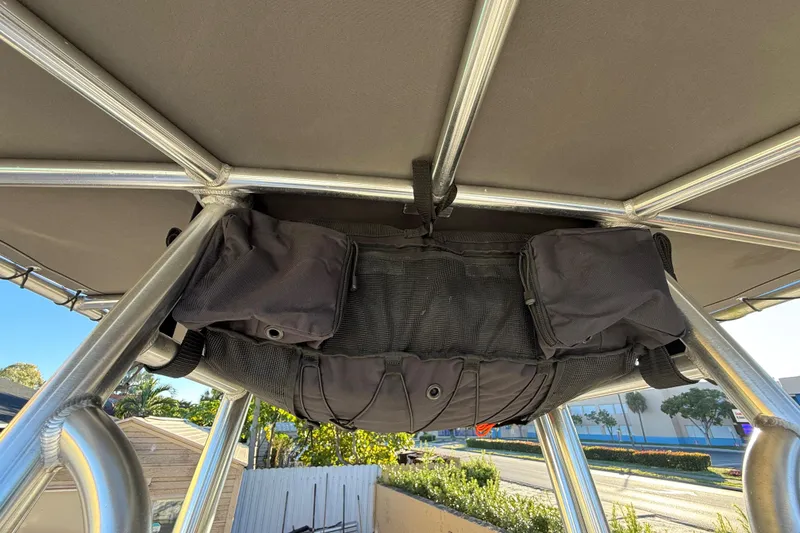 Slide: The Image of Storage compartment under canopy of 2022 Pathfinder 2005 TRS boat, featuring black bags and metal frame. - 47