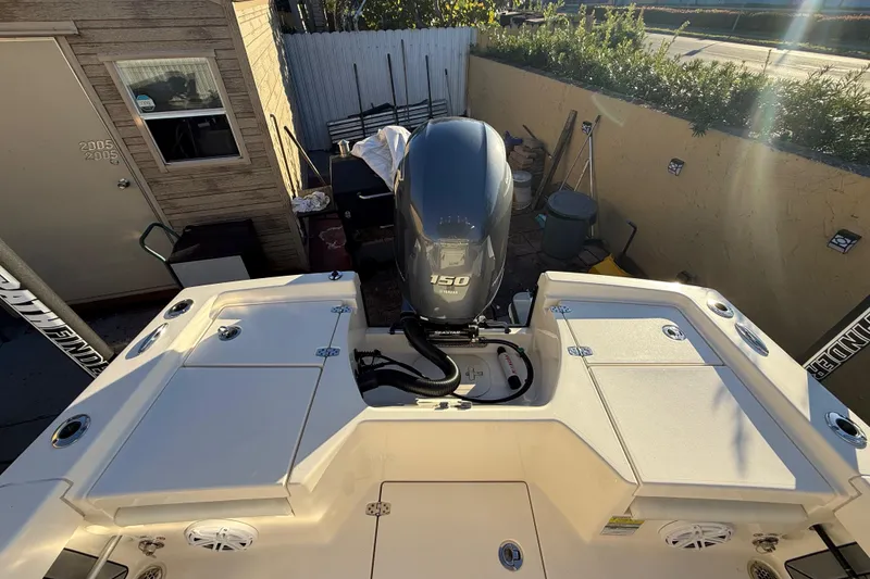 Slide: The Image of Pathfinder 2005 TRS boat with Yamaha 150 engine, docked in a sunny yard, 2022 model. - 51
