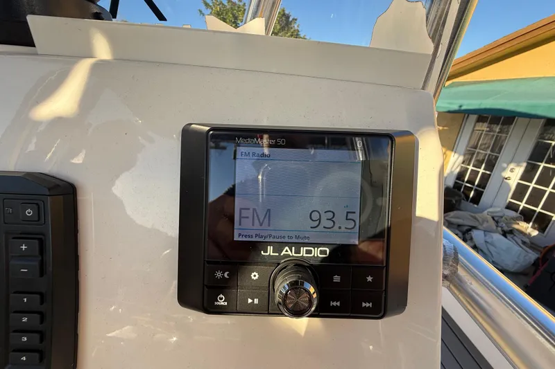 Slide: The Image of Boat dashboard with JL Audio radio displaying FM 93.5, Pathfinder 2005 TRS model. - 87
