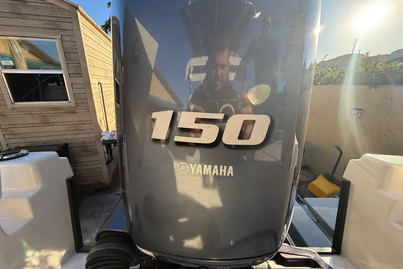 Slide: The Image of Yamaha 150 outboard motor on 2005 Pathfinder TRS, 2022 model, in sunny outdoor setting. - 98