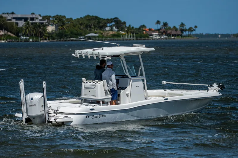 Slide: The Image of 2021 Caymas 26 HB boat cruising on a scenic waterway with two passengers. - 0