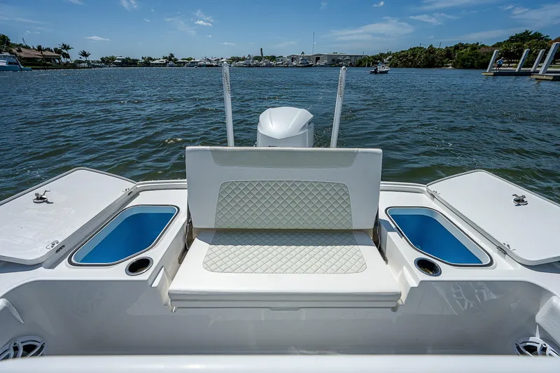 Slide: The Image of 2021 Caymas 26 HB boat interior with seating and storage, on a sunny day by the water. - 18