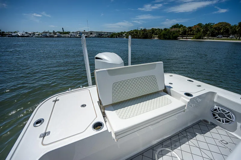 Slide: The Image of 2021 Caymas 26 HB boat with cushioned seating, docked on a sunny day. - 20