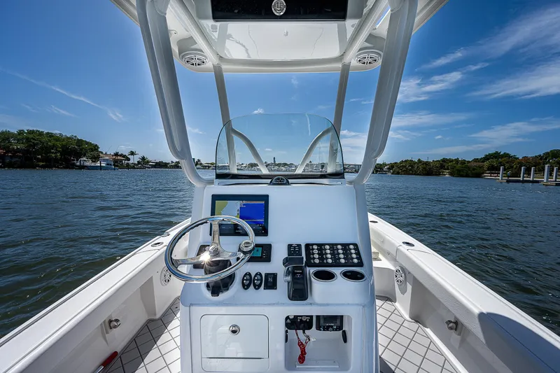 Slide: The Image of 2021 Caymas 26 HB boat console with steering wheel and navigation system on a sunny day. - 23