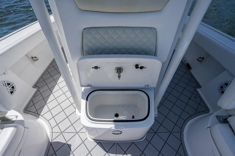 Slide: The Image of 2021 Caymas 26 HB boat interior with open storage compartment and cushioned seating. - 26