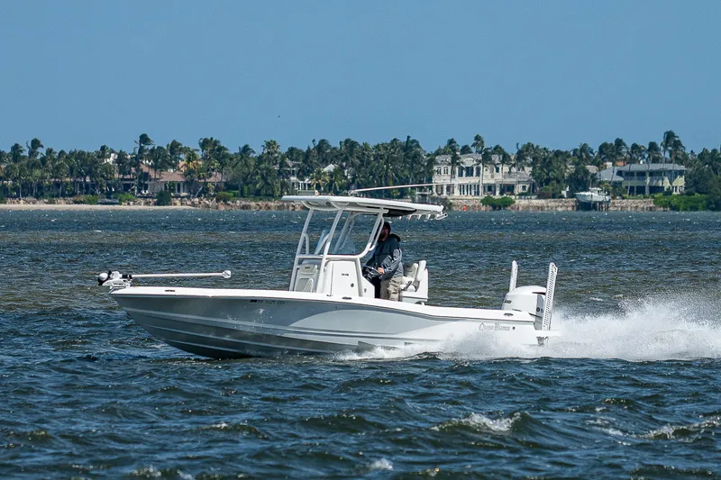 Slide: The Image of 2021 Caymas 26 HB boat cruising on water with scenic coastal background. - 3
