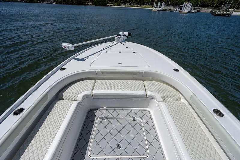 Slide: The Image of 2021 Caymas 26 HB boat bow with cushioned seating and trolling motor on calm water. - 32
