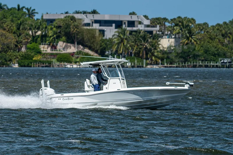 Slide: The Image of 2021 Caymas 26 HB boat cruising on a scenic waterway with lush greenery. - 4