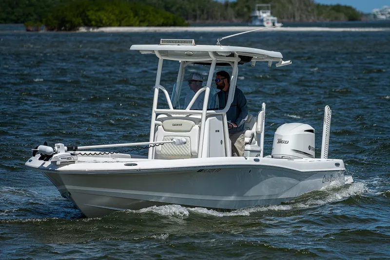 Slide: The Image of 2021 Caymas 26 HB boat cruising on open water with two passengers. - 6