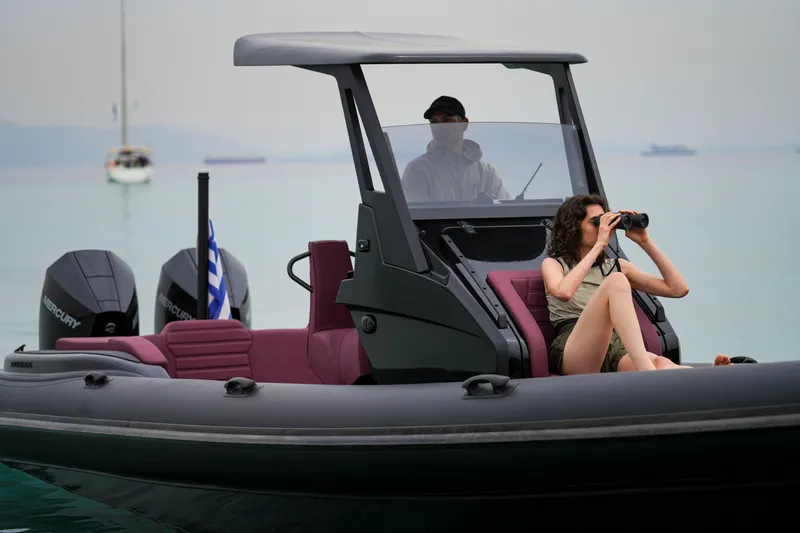 Slide: The Image of 2026 Rock Marine RM 30 boat with passengers, one using binoculars, on calm water. - 10