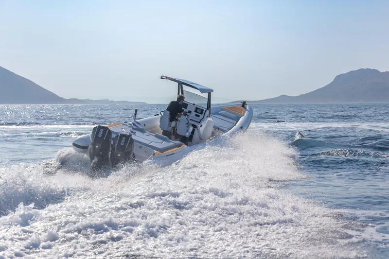 Slide: The Image of 2026 Rock Marine RM 30 speedboat cruising on open water with scenic mountain backdrop. - 2