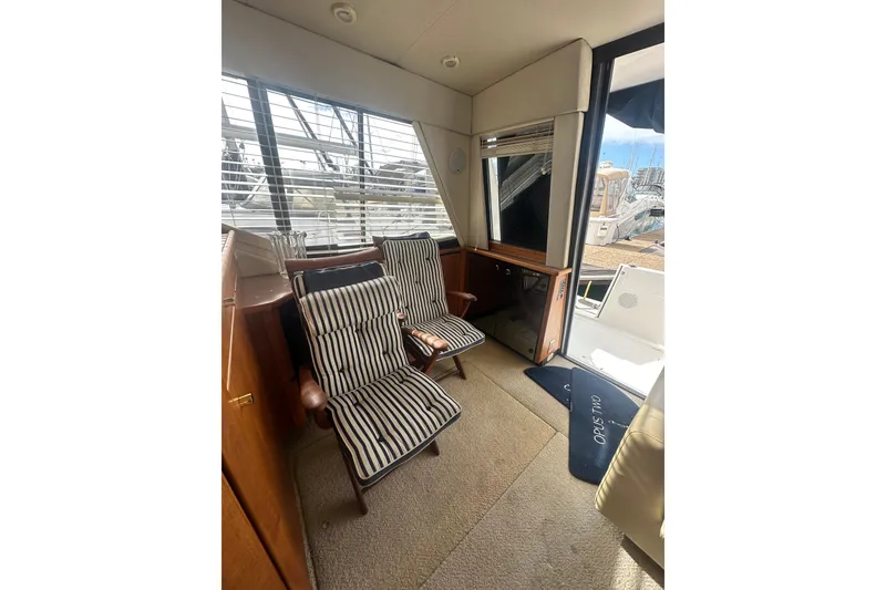 Slide: The Image of Interior of 1997 Bayliner 3988 Command Bridge Motoryacht with striped chairs and window view. - 46