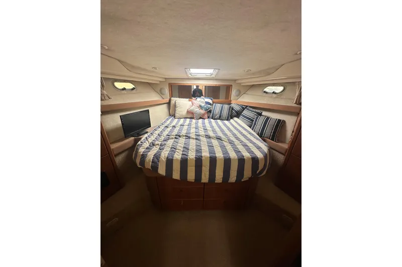 Slide: The Image of Luxurious cabin interior of 1997 Bayliner 3988 Command Bridge Motoryacht with striped bedding. - 49