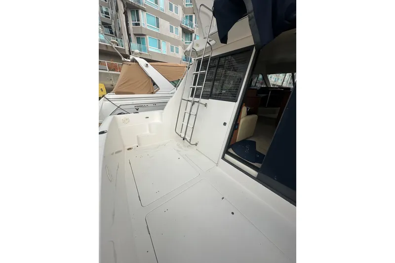 Slide: The Image of 1997 Bayliner 3988 Command Bridge Motoryacht, exterior view with ladder and open cabin door. - 54