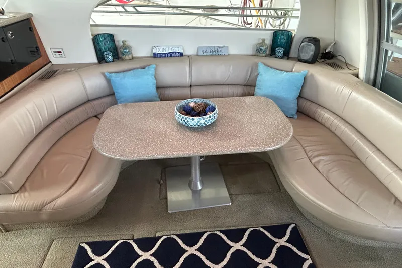 Slide: The Image of 1999 Maxum 4600 SCB yacht interior with seating and helm, docked at marina. - 31