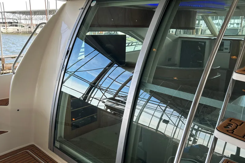 Slide: The Image of 1999 Maxum 4600 SCB yacht docked, showcasing sleek design and large windows. - 34